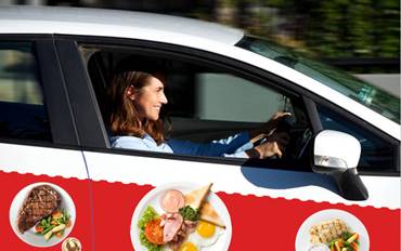 imagen de coche rotulado con publicidad de un restaurante